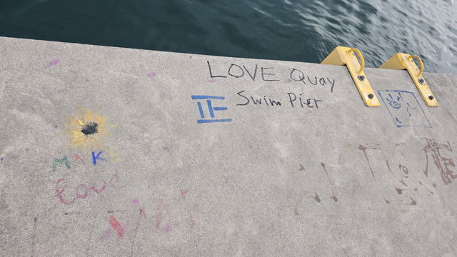 LOVE Quay Swim Pier written in chalk on the pier deck alongside a drawing of a ladder