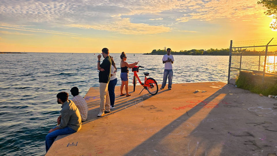 Walkers heading out along the pier as the sun drops toward the horizon