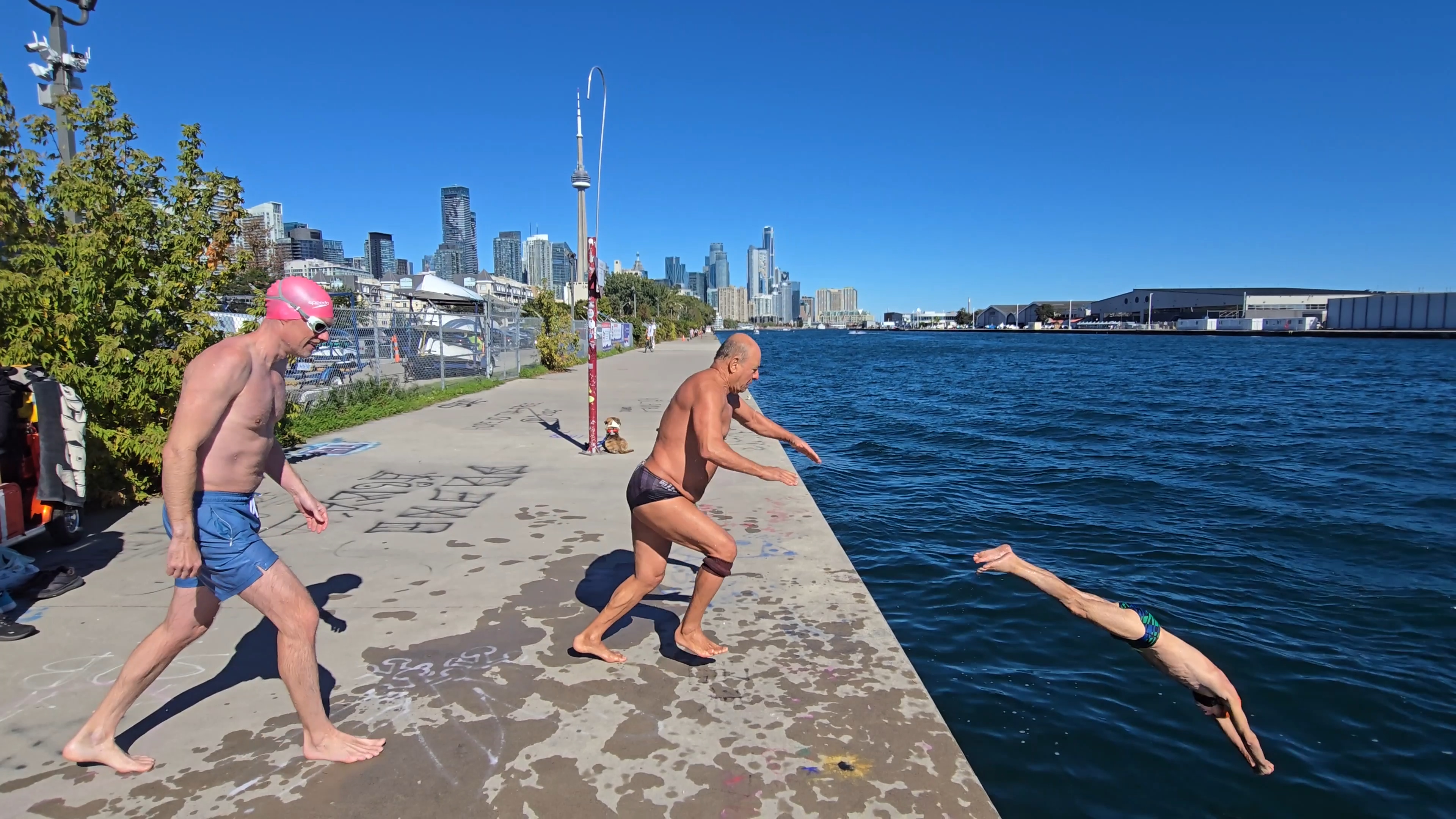 Three people jumping off Westmost end of pier