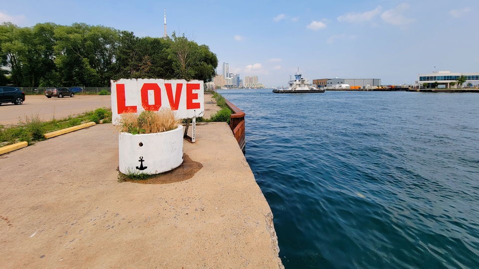 A LOVE-painted planter at the pier's edge on a clear summer afternoon