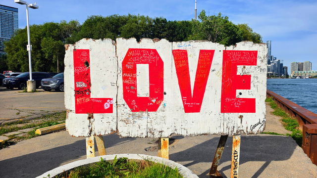 The LOVE installation seen from the roadway with the Toronto skyline and lake beyond